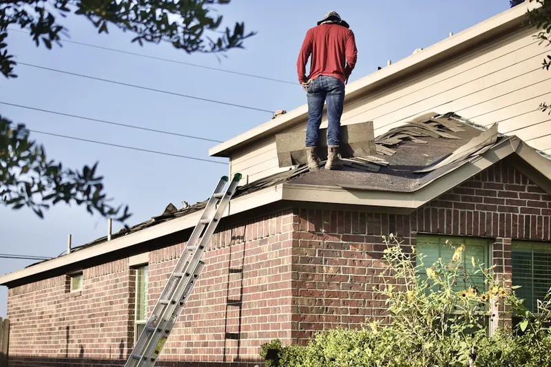 Professional roofer working on a residential roof in Alamo Placita